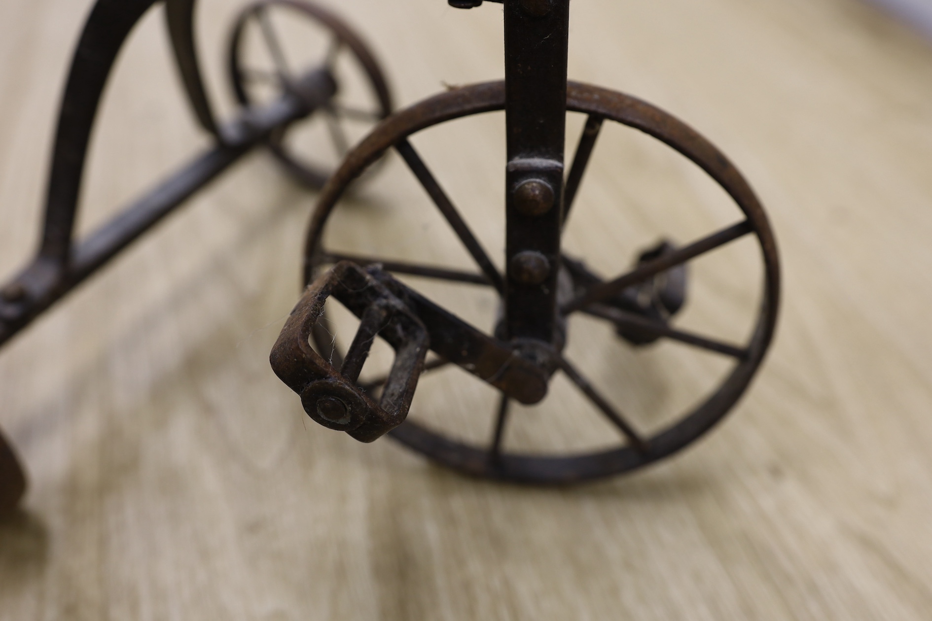 A cast iron toy model of a tricycle, a carved wooden bow, a classical figurative door knocker, a pair of metal cow shoes and two ceramic cistern pulls, bowl 30cm diameter. Condition - fair